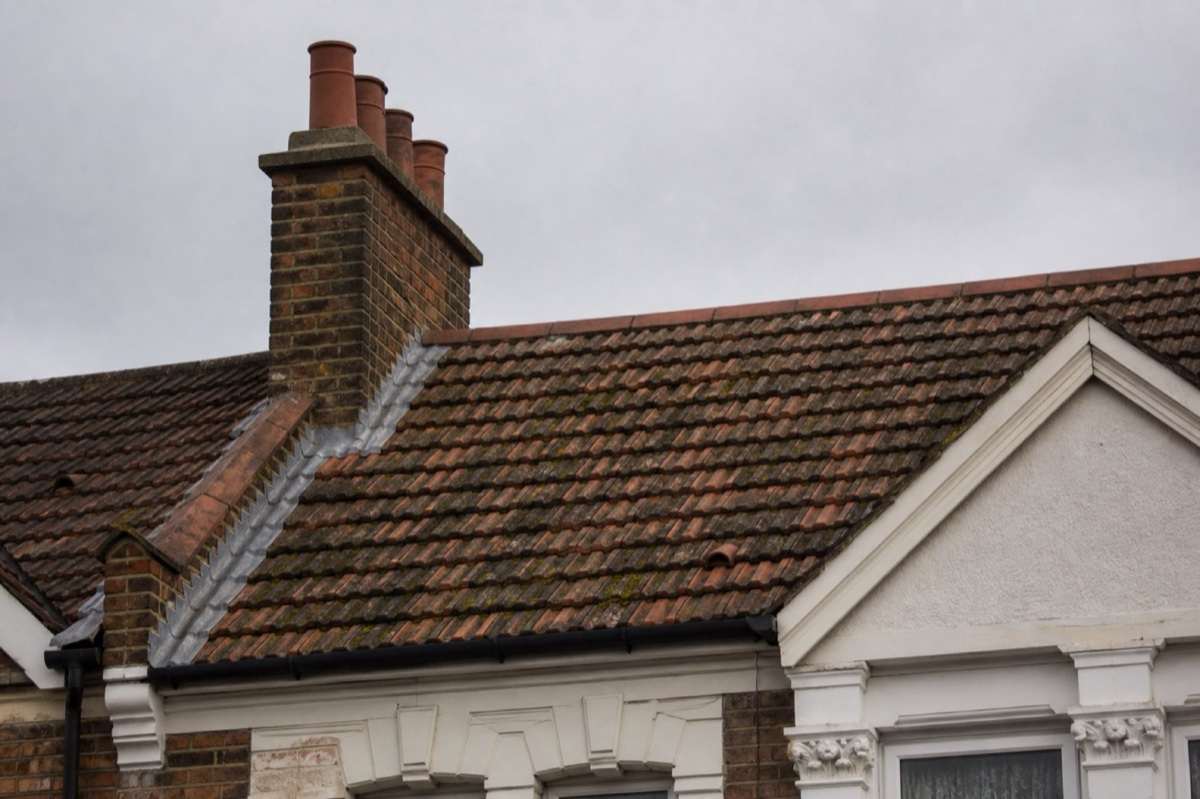 Weathered clay tiles and chimney on a London terrace